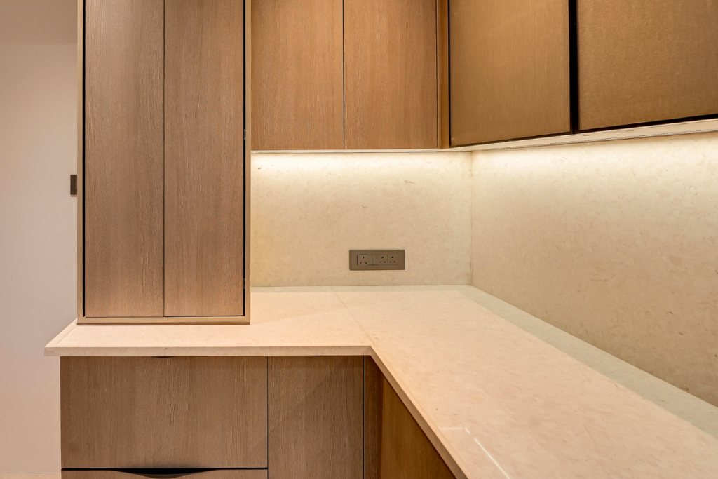Luxury L-shaped modular kitchen with wooden finish, stone countertop and under-cabinet lighting