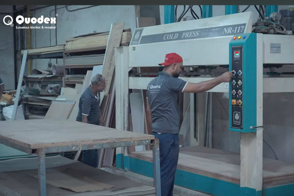 Quodex factory team operating machinery to process panels for modular kitchen manufacturing