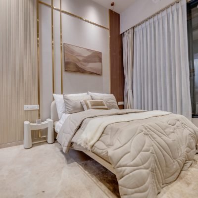Luxury beige bedroom with a modern upholstered bed, gold wall detailing, wood panels, and floor-to-ceiling curtains.