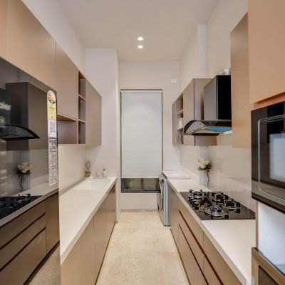 Modern parallel modular kitchen with beige cabinets, dual countertops, built-in appliances, and sleek storage